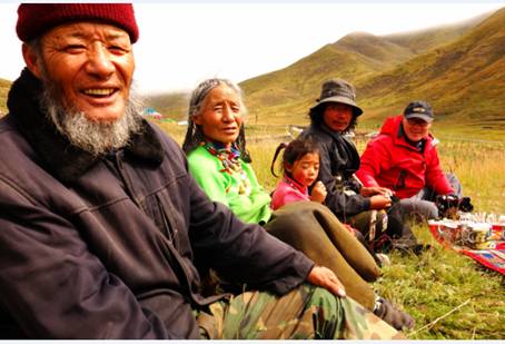青海果洛德尔文部落,队员们与73岁的达木桑大叔一家,在山坡上喝酥油茶